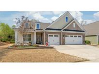 Charming two-story home featuring a brick facade, manicured lawn, and attached two car garage at 5002 Samoa Ridge Dr, Lancaster, SC 29270