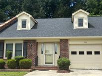 Charming single-Gathering home featuring a brick facade, dormer windows, and an attached garage at 550 Camrose Ne Cir, Concord, NC 28025