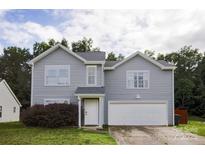 Charming two-story home with light gray siding, an attached garage, and manicured landscaping at 585 Gentle Breeze Ln, Rock Hill, SC 29730
