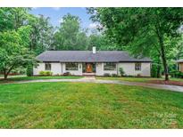 Charming single-story brick home with a well-manicured lawn and mature trees at 625 S Magnolia St, Mooresville, NC 28115