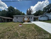 Charming one-story home featuring new siding, a carport, and a freshly poured concrete driveway at 801 Calhoun St, Lancaster, SC 29720
