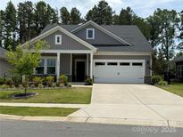 Charming single-story home with a well-manicured lawn, a two-car garage, and a welcoming front porch at 9009 Myrna Dr, Gastonia, NC 28056