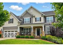 Charming two-story home with a welcoming front porch and manicured landscaping at 9511 Spurwig Ct, Charlotte, NC 28278