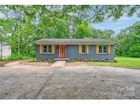 Charming single-story home featuring a brick facade, orange door, and yellow shutters at 1010 Fallston Rd, Shelby, NC 28150