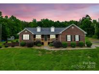 Charming brick home featuring a well-manicured lawn and a cozy front porch at 1060 S Lentz Harness Shop Rd, Mount Pleasant, NC 28124