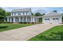 Inviting two-story home with a large front yard, driveway, and a detached three-car garage at 1621 Lakefield Cir, Gastonia, NC 28056
