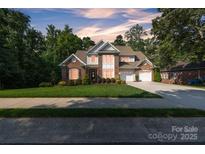 Stunning brick home boasts a manicured lawn and lush landscaping, with an attached two-car garage at 1747 30Th Avenue Ne Dr, Hickory, NC 28601