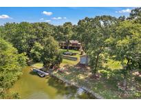 Waterfront home on a sunny day featuring a private dock and lush green landscaping at 2010 Dogwood Trl, Shelby, NC 28150