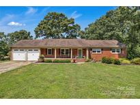 Charming brick home with a two-car garage, lush lawn, and manicured landscaping at 2010 Dogwood Trl, Shelby, NC 28150