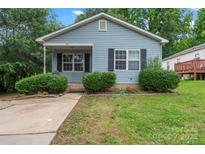 Charming single-story home with light blue siding, black shutters, and well-maintained landscaping at 301 Honeywood Ave, Charlotte, NC 28216