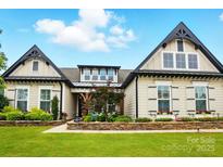 Charming home featuring a manicured lawn, stone accents, and symmetrical architectural details at 5357 Pembrey Dr, Denver, NC 28037