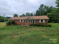 Charming single-story brick home with a well-maintained brown roof and bright white shutters at 603 Red Cedar Ln, Monroe, NC 28110