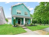Charming two-story home with a welcoming front porch, fresh landscaping, and vibrant curb appeal at 7931 Baylis Dr, Huntersville, NC 28078