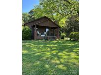 Charming bungalow with inviting front porch and rocking chairs, nestled in a lush green lawn and mature trees at 850 And 830 E Nc 152 E Hwy, China Grove, NC 28023
