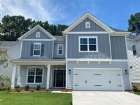 Charming two-story home with a well-manicured lawn, inviting entrance, and attached two-car garage at 9108 Dulwich Dr # Ken0074, Charlotte, NC 28215