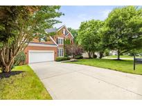 Charming brick home featuring a wide driveway, well-manicured lawn, mature trees, and a two-car garage at 11139 Tradition View Dr, Charlotte, NC 28269