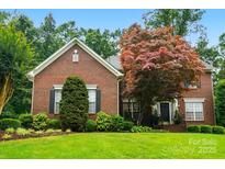 Charming two-story brick home with a well-manicured lawn and mature trees, offering classic curb appeal at 1720 Mountain Park Dr, Charlotte, NC 28214