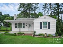 Charming home featuring a well-manicured lawn and a classic white exterior with decorative flower beds at 2108 Twin Ave, Gastonia, NC 28052