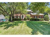 Stately brick home with a lush, green lawn and mature trees providing shade at 21621 Crown Lake Dr, Cornelius, NC 28031