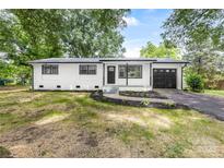 Charming renovated home with white brick exterior, black accents, and attached garage at 2280 Cannon Farm Rd, China Grove, NC 28023
