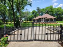 Charming home featuring manicured front yard with gated drive leading to beautifully landscaped front yard at 2777 Old South Nw Ct, Concord, NC 28027