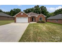 Charming brick home featuring a two-car garage and a well-manicured lawn at 3104 Doncaster Dr, Rock Hill, SC 29732