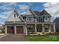 Beautiful two-story home with stone accents, well-manicured lawn, and inviting covered porch at 3224 Ashwood Park Dr # 295, Belmont, NC 28012