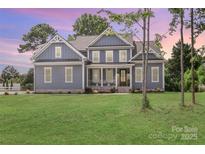 Charming two-story home with a large front lawn, blue siding, white trim, and a welcoming front porch at 332 Canvasback Rd, Mooresville, NC 28117