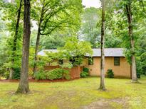 Quaint brick home nestled among mature trees and lush greenery, offering privacy and a serene setting at 5109 Goldcrest Dr, Indian Trail, NC 28079