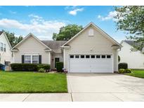 Charming single-story home featuring a well-manicured lawn and a two-car garage at 6303 Trevor Simpson Dr, Indian Trail, NC 28079