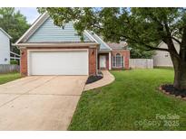 Charming single-story home with brick accents, a two-car garage, and a well-manicured front lawn at 8906 Pickering Grove Ln, Charlotte, NC 28216