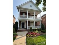 Charming brick home showcasing double porches, complemented by professional landscaping and a manicured lawn at 108 Forrester Ave, Belmont, NC 28012