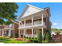 Charming brick home featuring a double front porch, manicured landscaping, and a welcoming facade at 108 Forrester Ave, Belmont, NC 28012