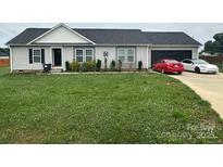 Charming single-story home featuring a well-maintained lawn and an attached two-car garage at 113 Grassland Dr, Mooresville, NC 28115