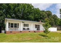 Charming single story home featuring a brick foundation, white siding, covered porch and a lush lawn at 1197 Fincher Rd, Fort Lawn, SC 29714