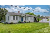 Charming single-story home with light gray siding, white trim, landscaped yard, and covered parking at 1266 18Th Ne St, Hickory, NC 28601