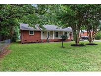 Charming brick home with a well-manicured lawn and mature trees at 1344 Shannonhouse Dr, Charlotte, NC 28215