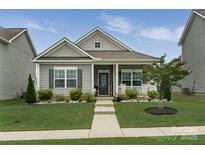 Charming single-story home with a welcoming front porch and well-manicured lawn at 148 Kerri Dawn Ln, Locust, NC 28097