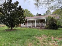 Charming single-story home with a cozy front porch and white picket fence, surrounded by green grass at 2096 S Point Rd, Belmont, NC 28012
