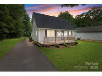 Charming home featuring a well-kept lawn, a driveway with basketball hoop, and a cozy front porch at 2146 Marwood Ln, Albemarle, NC 28001