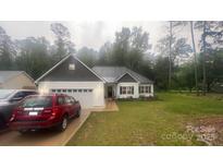 Charming single-story home with a white exterior, a dark shingled roof and an attached two-car garage at 2705 Enon Church Rd, Salisbury, NC 28147