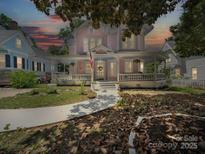 Charming pink Victorian home featuring a welcoming porch with a white railing and walkway at 408 S Ellis St, Salisbury, NC 28144