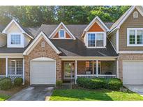 Charming townhome featuring a brick facade, attached garage, and inviting front porch at 4460 Coventry Row Ct, Charlotte, NC 28270