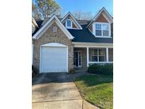 Charming brick townhome featuring a one-car garage and a cozy front porch with white railings at 4460 Coventry Row Ct, Charlotte, NC 28270