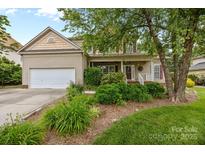 Charming home with a well-maintained lawn, mature landscaping, and a cozy front porch at 6533 Derby Nw Ln, Concord, NC 28027