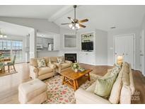 Inviting living room featuring a fireplace, built-in shelving, and seamless flow to the kitchen for modern living at 1148 Stallings Rd, Matthews, NC 28104