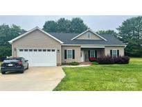 Charming single-story home featuring a two-car garage and a welcoming front porch with curb appeal at 129 Sara Ln, Statesville, NC 28625