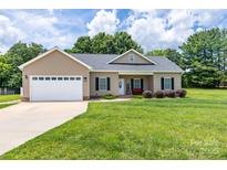 Charming single-story home with a two-car garage, manicured lawn, and attractive landscaping at 129 Sara Ln, Statesville, NC 28625