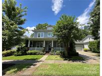 Charming home featuring a cozy front porch, complemented by lush landscaping and a well-manicured lawn at 16909 Red Cow Rd, Charlotte, NC 28277