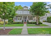 Charming two-story home with a welcoming front porch, manicured lawn, and mature trees at 16909 Red Cow Rd, Charlotte, NC 28277